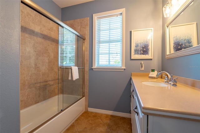 bathroom with bath / shower combo with glass door, vanity, a healthy amount of sunlight, and tile patterned flooring