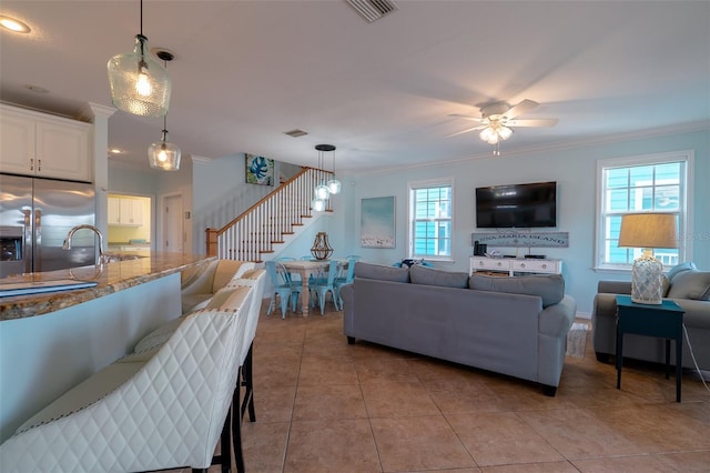 living room with ceiling fan, a healthy amount of sunlight, and crown molding