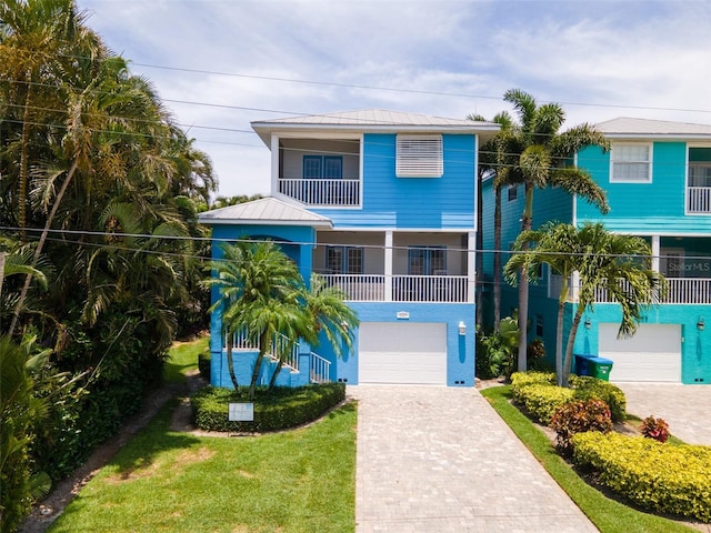 coastal home with a garage and a front yard