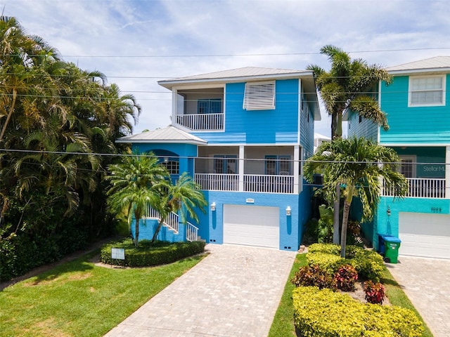 coastal home with a garage and a front yard