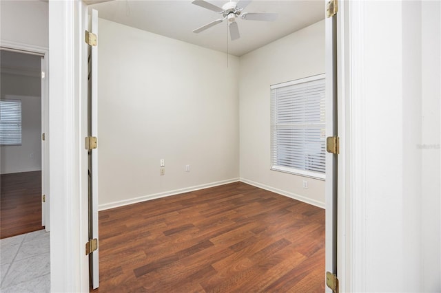 unfurnished room with dark hardwood / wood-style flooring and ceiling fan