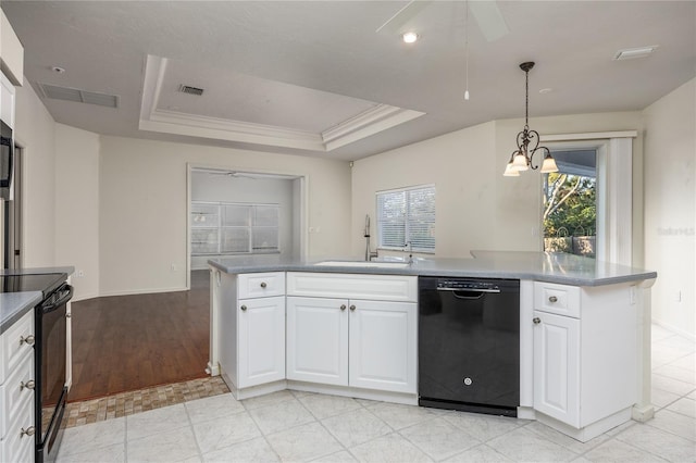 kitchen featuring a raised ceiling, sink, black appliances, pendant lighting, and white cabinets