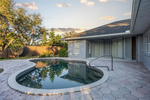 pool at dusk featuring a patio