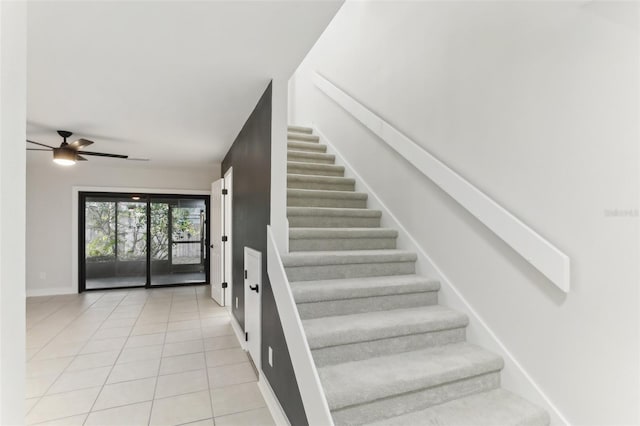 stairs featuring tile patterned flooring and ceiling fan