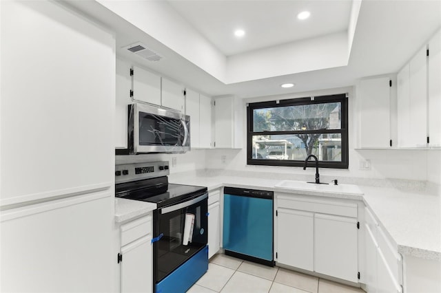 kitchen with white cabinets, appliances with stainless steel finishes, light tile patterned floors, and sink