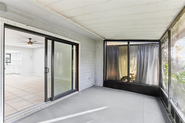 unfurnished sunroom featuring ceiling fan