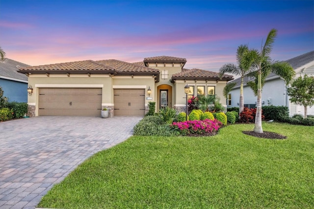 mediterranean / spanish-style house featuring a garage and a lawn