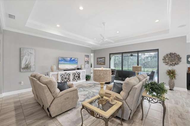 tiled living room with a tray ceiling, ceiling fan, and crown molding