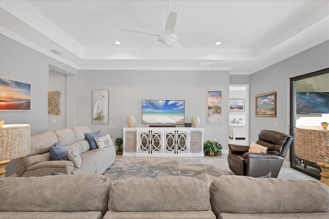 living room featuring a raised ceiling, ceiling fan, and crown molding