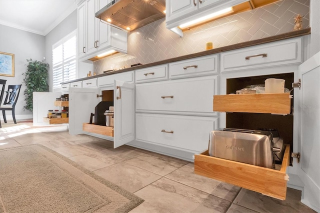 kitchen with decorative backsplash, white cabinetry, crown molding, and wall chimney range hood