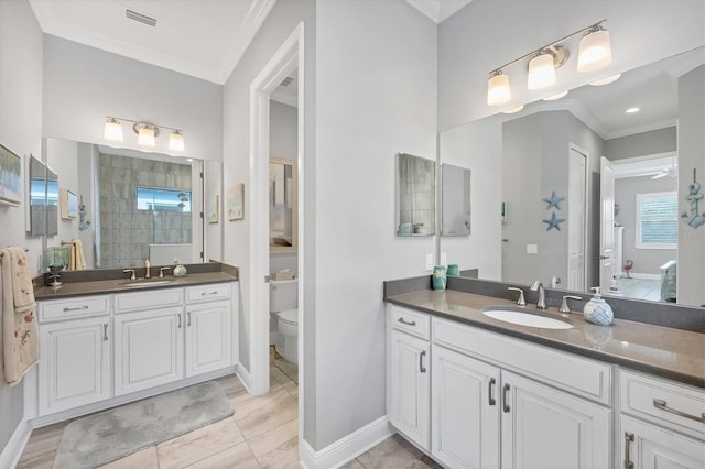 bathroom with ornamental molding, vanity, tiled shower, tile patterned flooring, and toilet