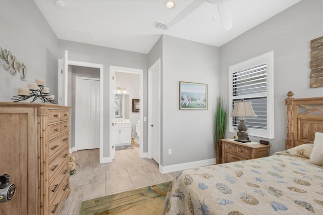 tiled bedroom featuring ceiling fan and ensuite bath