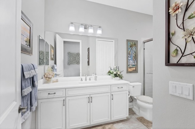 bathroom featuring tile patterned flooring, vanity, toilet, and walk in shower