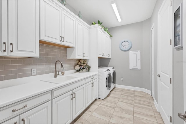 laundry room featuring separate washer and dryer, sink, light tile patterned flooring, and cabinets