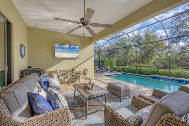 view of swimming pool featuring a patio, an outdoor hangout area, glass enclosure, and ceiling fan