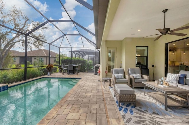 view of pool featuring outdoor lounge area, ceiling fan, a lanai, area for grilling, and a patio