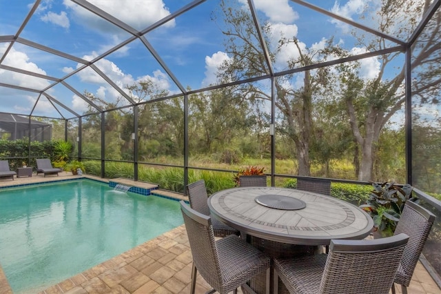 view of pool with a patio, pool water feature, and a lanai