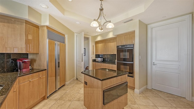 kitchen with paneled fridge, black double oven, a textured ceiling, decorative backsplash, and a kitchen island