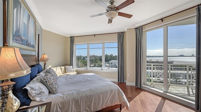 bedroom featuring access to exterior, hardwood / wood-style flooring, multiple windows, and ceiling fan