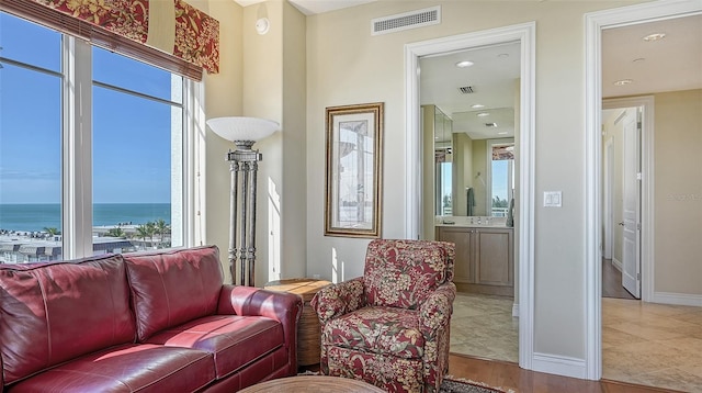 sitting room featuring a water view and light hardwood / wood-style floors