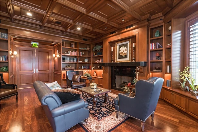 living area featuring built in shelves, dark wood-type flooring, coffered ceiling, and ornamental molding