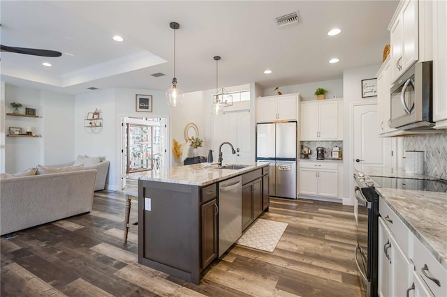 kitchen featuring a center island with sink, white cabinets, and stainless steel appliances