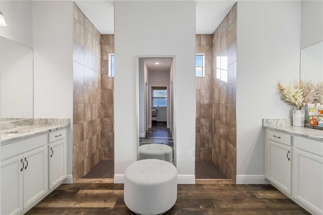 bathroom with a tile shower, hardwood / wood-style floors, and vanity