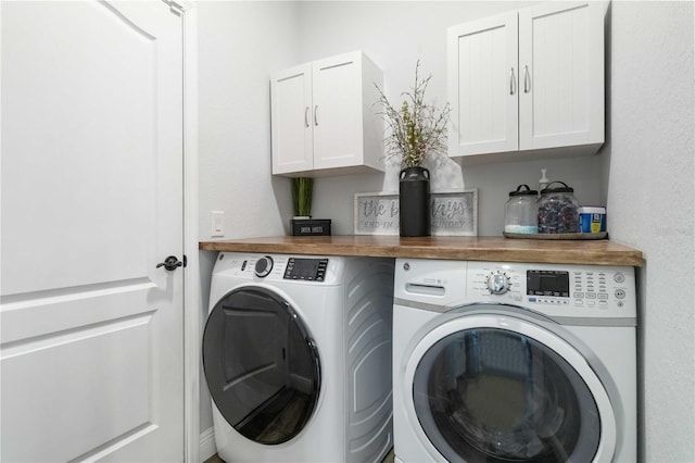 clothes washing area with washer and clothes dryer and cabinets