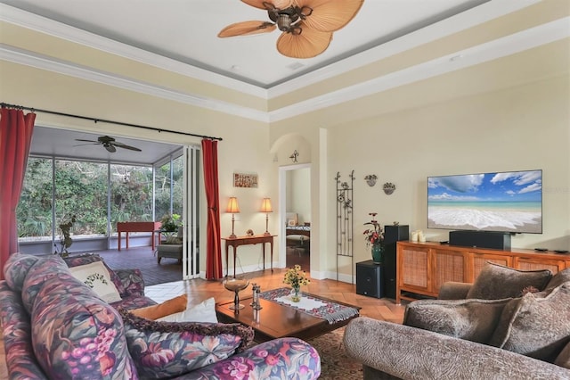 living room with a raised ceiling and crown molding