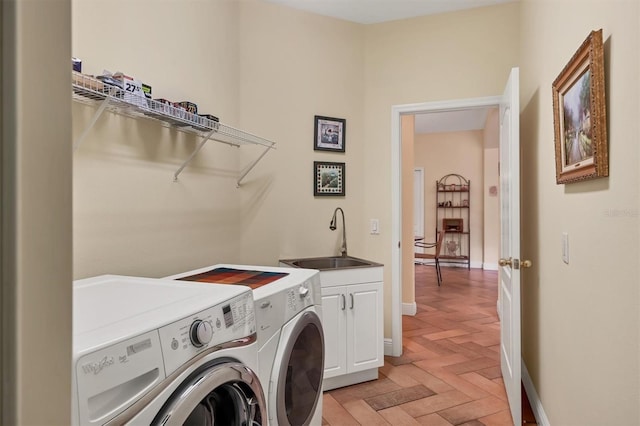 laundry room with sink, light parquet flooring, cabinets, and independent washer and dryer