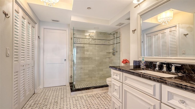 bathroom featuring toilet, vanity, a notable chandelier, and tiled shower