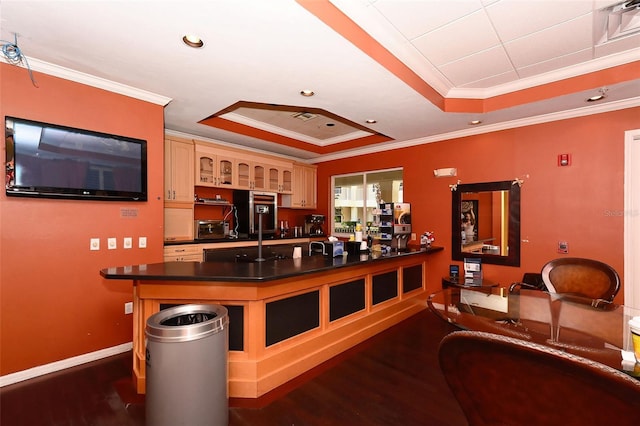 bar with a tray ceiling, cream cabinets, dark hardwood / wood-style flooring, and ornamental molding