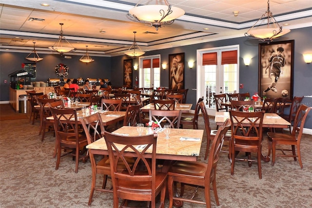 dining room with carpet, french doors, a raised ceiling, and ornamental molding