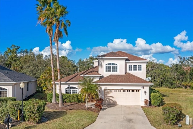 mediterranean / spanish-style house with a garage and a front lawn