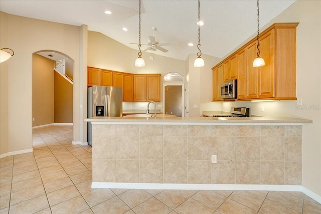 kitchen with sink, ceiling fan, appliances with stainless steel finishes, light tile patterned flooring, and kitchen peninsula