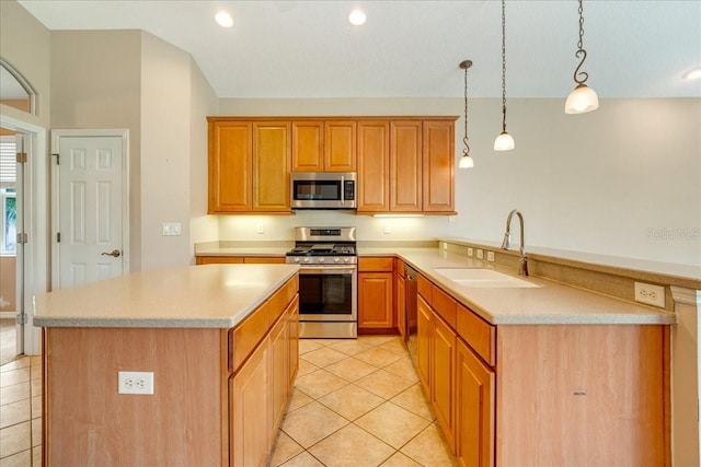 kitchen featuring kitchen peninsula, appliances with stainless steel finishes, sink, light tile patterned floors, and decorative light fixtures