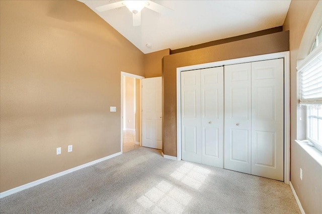 unfurnished bedroom featuring a closet, vaulted ceiling, ceiling fan, and light colored carpet