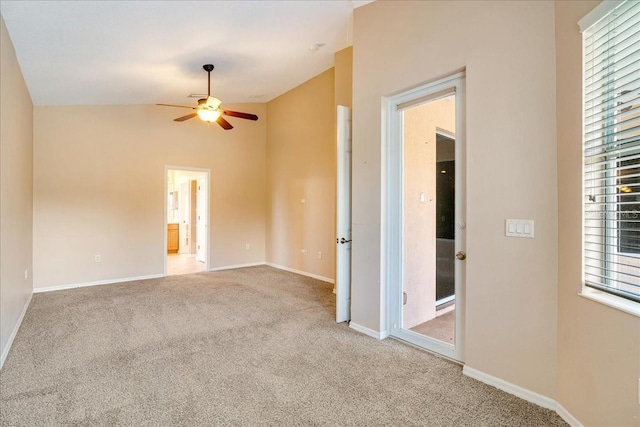 unfurnished room with carpet, vaulted ceiling, and plenty of natural light