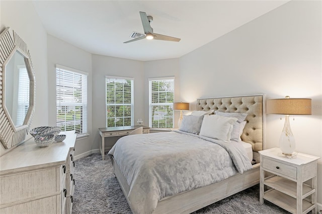 bedroom featuring multiple windows, ceiling fan, and dark carpet