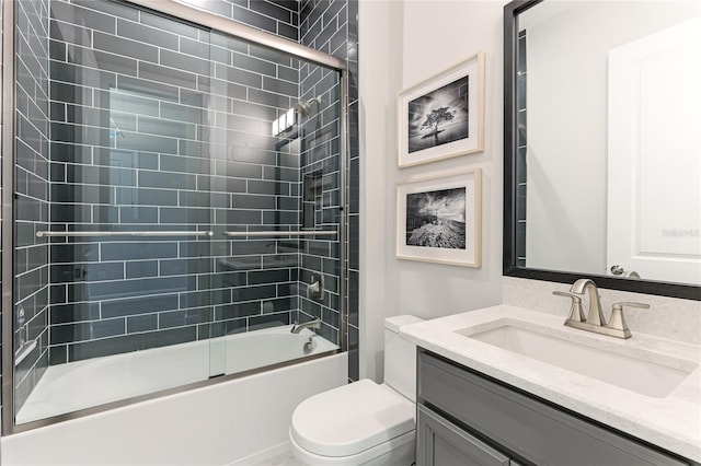 full bathroom featuring shower / bath combination with glass door, vanity, and toilet