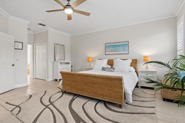 bedroom with light tile patterned flooring, ceiling fan, ornamental molding, and a closet