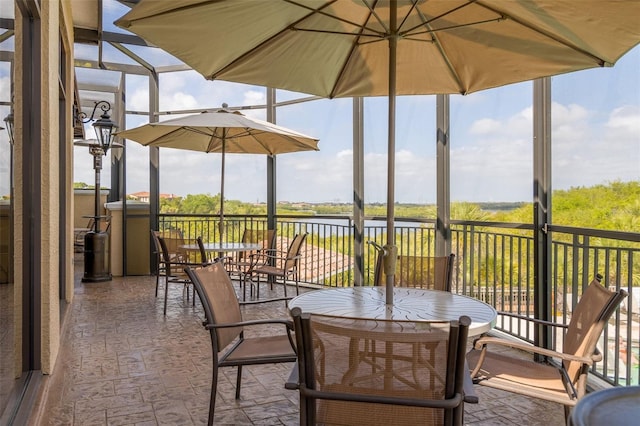 view of patio / terrace featuring a water view and a lanai