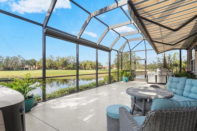 view of patio / terrace featuring grilling area, exterior kitchen, glass enclosure, and a water view