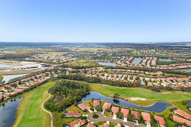 aerial view with golf course view, a water view, and a residential view