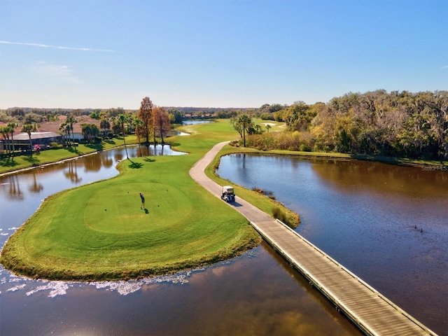 drone / aerial view featuring view of golf course and a water view