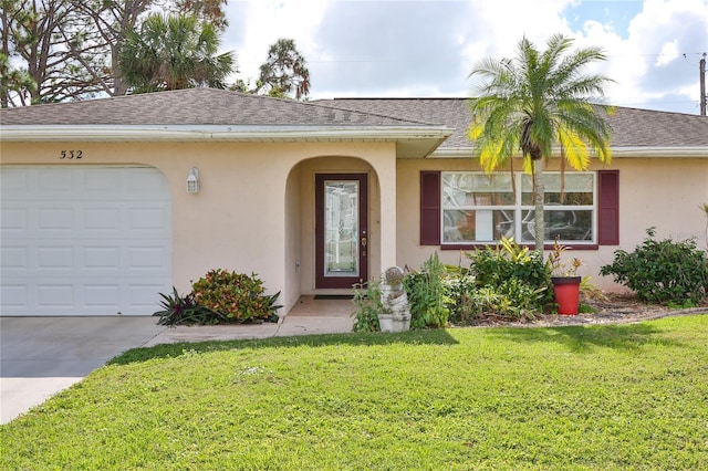 view of exterior entry featuring a garage and a yard