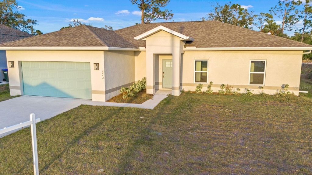 single story home with a garage and a front lawn