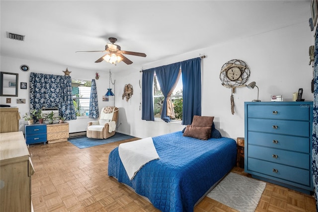 bedroom featuring a baseboard heating unit, ceiling fan, and light parquet floors