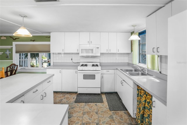 kitchen featuring sink, white appliances, white cabinetry, and hanging light fixtures