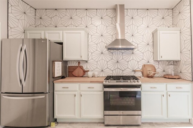 kitchen with backsplash, wall chimney exhaust hood, white cabinetry, and stainless steel appliances